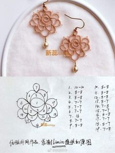 a pair of earrings is shown on a piece of paper with chinese writing in the background