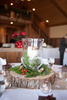 the table is set with white linens, silverware and candles for an elegant centerpiece