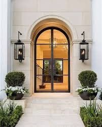 an entrance to a home with two large potted plants on either side of the door