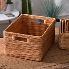 two wicker baskets sitting on top of a wooden table next to eachother