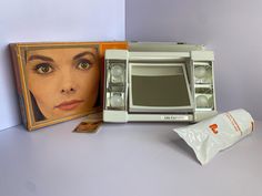 an old model microwave with the door open next to it's packaging and its contents