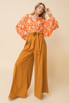 A solid woven pant featuring inverted pleated front, attached self sash tie at side, extra wide leg and size zipper closure Details Self: :95% Polyester, 5% Spandex Size & Fit - Model is 5`8" And Wearing Size Small - Measurements Taken From Size Small - Approx. Length: 46" Trendy Orange Wide-leg Pants, Orange Wide-leg Pants With Relaxed Fit, Orange Wide-leg Beach Pants, Bohemian Orange Wide-leg Pants, Luxury Orange Wide-leg Pants, Wide Leg, Fitness Models, Pants, How To Wear