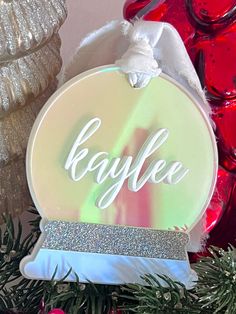 a christmas ornament with the word byele on it and some ornaments in the background