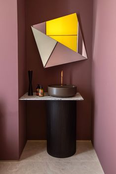 a bathroom with a sink, mirror and vase on the counter in front of it