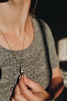 Lighthouse · Diamond Quartz, Moonstone, Smoky Quartz Necklace The different earthy tones in this piece is everything my neutral-loving self could ever want. Every necklace has the same order of stones: creamy white Moonstones anchoring the top and bottom, a sparkling clear Diamond Quartz, and two deeper Smoky Quartz crystals.The crystals are carefully positioned onto a bar that lays flat against your chest.Lightweight, works perfectly as an everyday piece.Adjustable chain length makes it so it c Everyday White Jewelry With Moon Charm, Everyday White Moon Charm Jewelry, Spiritual Oval Pendant Jewelry For Everyday, Everyday Spiritual Oval Pendant Jewelry, Spiritual Moon Charm Jewelry For Everyday, Spiritual Jewelry With Moon Charm For Everyday, Everyday Spiritual Moon Charm Jewelry, Elegant Moon Phase Necklace, Everyday Round Necklaces With Natural Stones