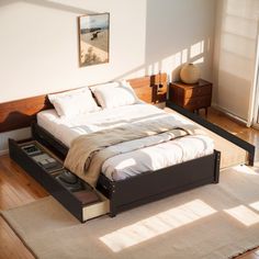 a bed sitting on top of a wooden floor next to a window