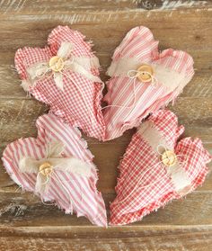 several pieces of fabric with buttons on them sitting on a wooden surface, tied together