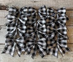 the black and white buffalo plaid bow is hanging on a wooden wall