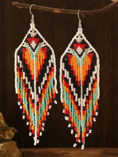 Add a touch of bohemian elegance to your style with these exquisite handmade glass bead earrings. Crafted with love and care, these intricate earrings feature a beautiful design showcasing a harmonious blend of orange, red, black, white, and turquoise beads. Inspired by American Indian and Indigenous designs, these earrings are perfect for adding a pop of color and a unique flair to any outfit. The stunning array of colors brings warmth and vibrancy, making these earrings a standout accessory for any occasion. Embrace the blend of boho chic and heartfelt artistry with these captivating earrings. Bohemian Teardrop Dangling Beads, Bohemian Teardrop Earrings With Large Beads, Bohemian Orange Tassel Earrings, Elegant Multicolor Beaded Earrings With Tiny Beads, Bohemian Beaded Earrings With Fringe, Traditional Multicolor Beaded Fringe Tassel Earrings, Bohemian Teardrop Beaded Earrings With Colorful Beads, Bohemian Dangle Earrings With Large Beads, Bohemian White Tassel Earrings With Colorful Beads