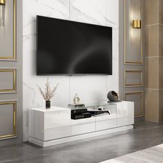 a large flat screen tv mounted to the side of a white cabinet in a living room