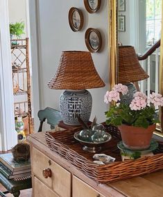 a wicker basket with flowers in it on top of a dresser next to a mirror