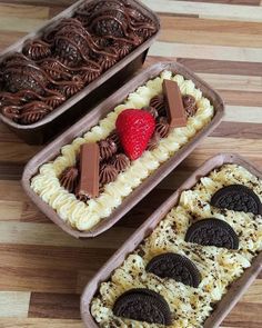 two trays filled with cookies and strawberries on top of a wooden table