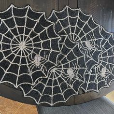 a black and white spider web on a wooden surface