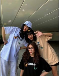 three young women posing for the camera in front of a building