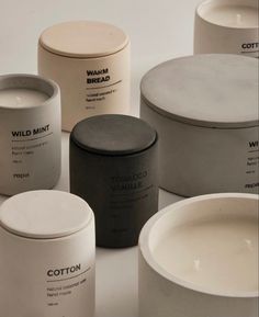 several white and black containers sitting on top of a table next to each other in front of one another