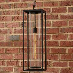 a light hanging from the side of a brick wall