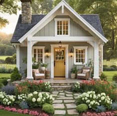 a small house with lots of flowers around the front door and steps leading up to it