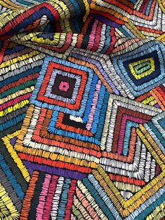 a colorful piece of cloth with different colors and patterns on the fabric, as well as lines