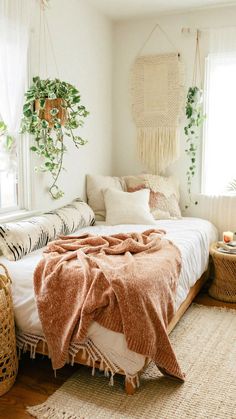 a bedroom with plants and blankets on the bed