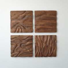 four square pieces of wood are arranged on a white surface