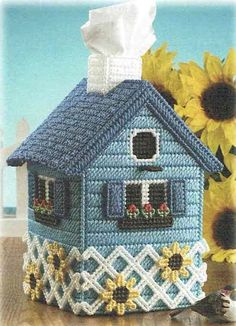 a blue house with sunflowers and a white towel on the table next to it