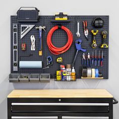 a workbench with tools hanging on the wall