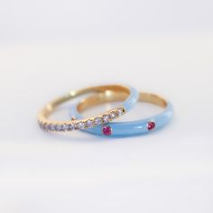 This is a great ring to wear on its own but works even better in a stack. You can really make a whole rainbow of colors on your finger with just a couple of rings! Let’s play! Precious Metal: 18K Solid Yellow Stones: Pink Sapphire with Baby Blue Enamel, Ruby with Peach Enamel or Blue Sapphire with Neon Yellow Enamel .05ct each design Enamel Colors: Baby Blue, Peach or Neon Yellow Sizes: 7 Width: 2.4mm Other rings shown on the pictures are sold separately. Wear with care and avoid harsh chemicals Blue Enamel Ring, Pink Stackable Enamel Ring As A Gift, Pink Enamel Stackable Ring As Gift, Blue Enamel Ring With Gemstone For Gift, Polished Yellow Gold Enamel Ring, Blue Enamel Ring With Gemstone, Yellow Gold Polished Enamel Ring, Blue Stackable Enamel Ring, Pink Enamel Stackable Jewelry