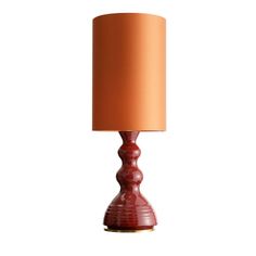 a red table lamp with an orange shade on it