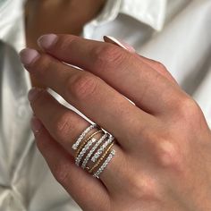 a woman's hand with three rings on her finger and one ring in the middle