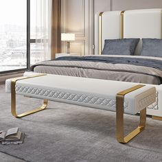 a white and gold bed sitting in a bedroom next to a window