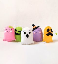 five halloween candy bags with faces and noses on them, lined up in a row