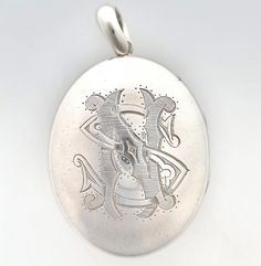 "An impressive, large, antique oval locket crafted in silver, the front of which has been hand-engraved with the monogrammed initials \"NS\" or \"SN\". A fantastic late Victorian or early Edwardian era piece which looks great paired with a thick silver chain. Circa 1895. Unmarked, tested as silver. The locket measures approximately 65mm (L) x 40.4mm (W). The approximate weight is 32.5 grams. Please note that the chain pictured is for display purposes only. Thank you. CONDITION: In very good antique condition with some light surface wear commensurate with age. The locket opens and closes as it should. LAYAWAY: We happily offer layaway/deposits on the majority of our items. Please send us a message if you would like to arrange a layaway. Layaways are not available on sale items. SHIPPING: Al Ornate Engraved Antique Silver Locket Necklace, Victorian Oval Locket Necklace With Intricate Design, Ornate Oval Locket Necklace For Wedding, Ornate Engraved Locket Necklace For Formal Occasions, Ornate Engraved Locket Necklace For Formal Events, Antique Silver Hallmarked Locket Necklace, Antique Sterling Silver Locket Necklace, Engraved Antique Silver Locket Necklace For Anniversary, Antique Engraved White Gold Locket Necklace