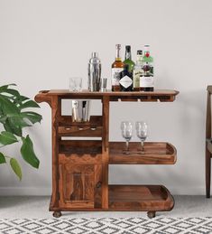 a wooden bar cart with wine glasses and bottles on it