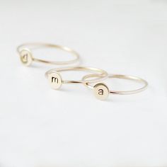 One gold letter ring. Personalize a gift she'll treasure with our gold initial ring. An adorably petite initial, imprinted on a 14k gold filled disk - paired with a super skinny (1mm) gold filled band - creates the perfect stacking ring, customized with your monogram. Lovely as a stand alone. Also sits beautifully with multiple initials stacked or our hammered gold stacking ring bands. This gold initial ring arrives custom made to order in your size hand stamped with the letter of your choice. A Gold Stackable Rings With Initials For Everyday, Everyday Gold Stackable Rings With Initials, Dainty Gold Stackable Rings With Initials, 14k Gold Stackable Rings With Initials, Simple Gold Stackable Initial Ring, Dainty Stackable Rings With Initials For Promise, Gold Monogram Initial Ring For Everyday, Gold Monogram Initial Ring For Everyday Wear, Gold Sterling Silver Initial Stackable Ring