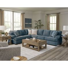 a living room with blue couches and white rugs on the hardwood flooring