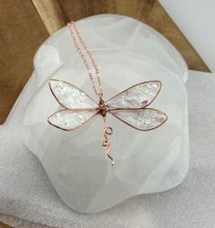 ❤️100% Handmade Copper Wire & UV epoxy Dragonfly Pendant Necklace with multiple color options.  This is a 100% Handmade Dragonfly pendant necklace designed, and made by me, Elle!  I make these Dragonflies using pure copper wire which I hand shape into each wing, even adding the veins within the wing depending on the colors chosen. After the Dragonfly sections are made I fill them with UV epoxy, adding natural Mica powder to change the colors.  The necklace pendant is about 3" wide and 1.5-1.75" long.  Large enough to be noticed, but not bulky. They are delicate looking but strong. Feel free to ask for any color, or ombre pattern on your earrings, or necklace. Shown is a clear with sparkle option, a iridescent pearl white with sparkle option, and a ocean ombre dragonfly. Feel free to ask fo White Dragonfly Jewelry Gift, Handmade Whimsical Butterfly Necklace, Whimsical Handmade Butterfly Necklace, Adjustable Wing-shaped Jewelry Gift, Adjustable Wing-shaped Jewelry For Gifts, Iridescent Wire Wrapped Necklace For Gift, Handmade Iridescent Butterfly Jewelry, Iridescent Butterfly-shaped Handmade Jewelry, Handmade Iridescent Jewelry In Butterfly Shape