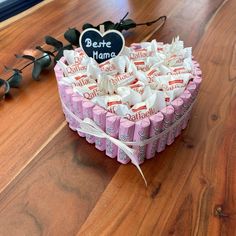 a heart shaped box filled with candies on top of a wooden table