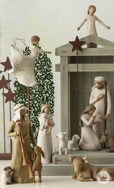 a group of figurines sitting on top of a white table next to a christmas tree