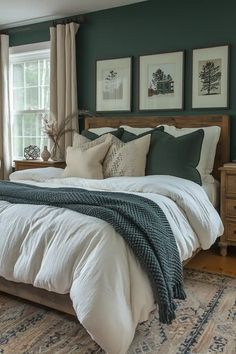 a large bed sitting next to a window in a bedroom under two pictures on the wall