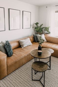 a living room with couches, tables and pictures hanging on the wall above them