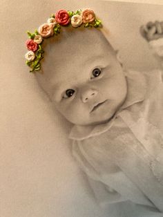 a baby is wearing a flower crown on her head