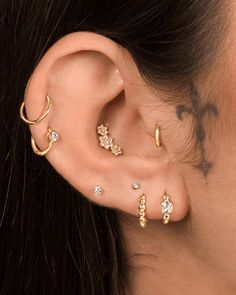 an ear with three different types of piercings on it and the words assolari written