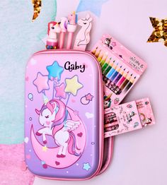 a pink pencil case with unicorns and stars on the front, along with other stationary items