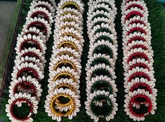 several pieces of paper flowers are laid out in rows on the grass, ready to be made into brooches