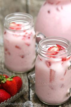 two mason jars filled with yogurt and strawberries