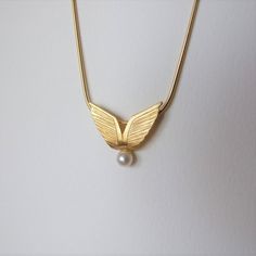 "This is a unique necklace, inspired by angel wings. It's very elegant and is great to give as a gift. It's made of 14k gold and you can choose which color 14k gold it will be made of - yellow or white gold I plate the white gold with rhodium, as is common in white gold jewelry. There is a single natural white pearl attached to the bottom of the pendant and the pendant has an elegant matte finish. The size of the pendant is 0.81 / 0.7 inches ( 2.1 / 1.8 cm ) Choose the length of the necklace you Elegant Gold Wing-shaped Jewelry, Elegant Wing-shaped Gold Jewelry, Elegant Angel Wings Necklaces, Elegant Jewelry Pendant With Angel Wings, Gold Winged Necklace Perfect As A Gift, Gold Winged Necklace For Gift, Angelic Gold Pendant Necklace, Elegant Angel Wings Pendant Jewelry, Elegant Gold Winged Jewelry