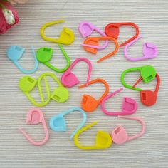 colorful plastic clips on a table with flowers in the background