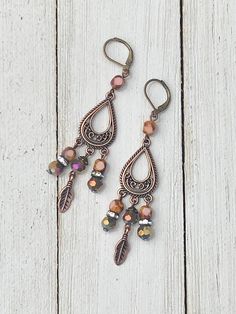 "Bohemian Feather Chandeliers" These Dangle Earrings feature gorgeous Boho Copper findings, faceted pink Czech beads, copper feather drops and AB Iridescent faceted beads and Rhinestone Rhondell Beads. The Copper, Pink and Purple colors look beautiful with a summer tan! I designed these Earrings by combining the pink faceted Czech beads with the tear drop Boho Copper finding, then making drops using combinations of the Czech beads, AB faceted beads, Rhinestone Rhondells and copper feather drops. Feather Chandelier, Earring Inspo, Earrings Boho Chic, Summer Tan, Dangle Earrings Boho, Boho Feathers, Earring Ideas, Earrings Inspiration, Pretty Jewelry