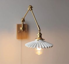 a wall light that is attached to the side of a wall with a lamp on it