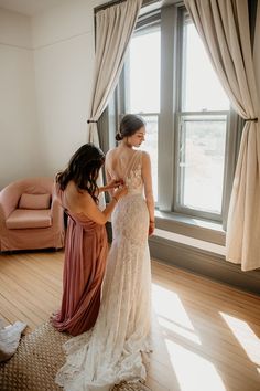 two women standing in front of a window